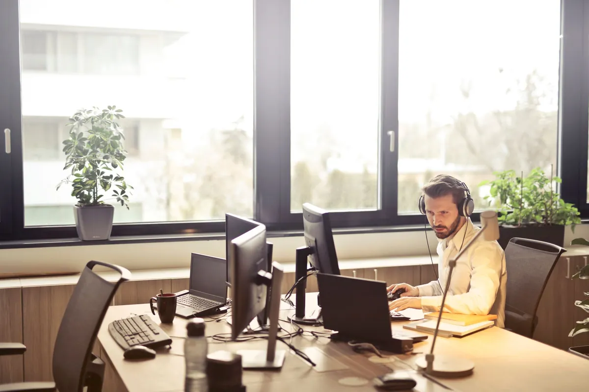 Dispatcher wearing a headset working at a multi-screen desk
